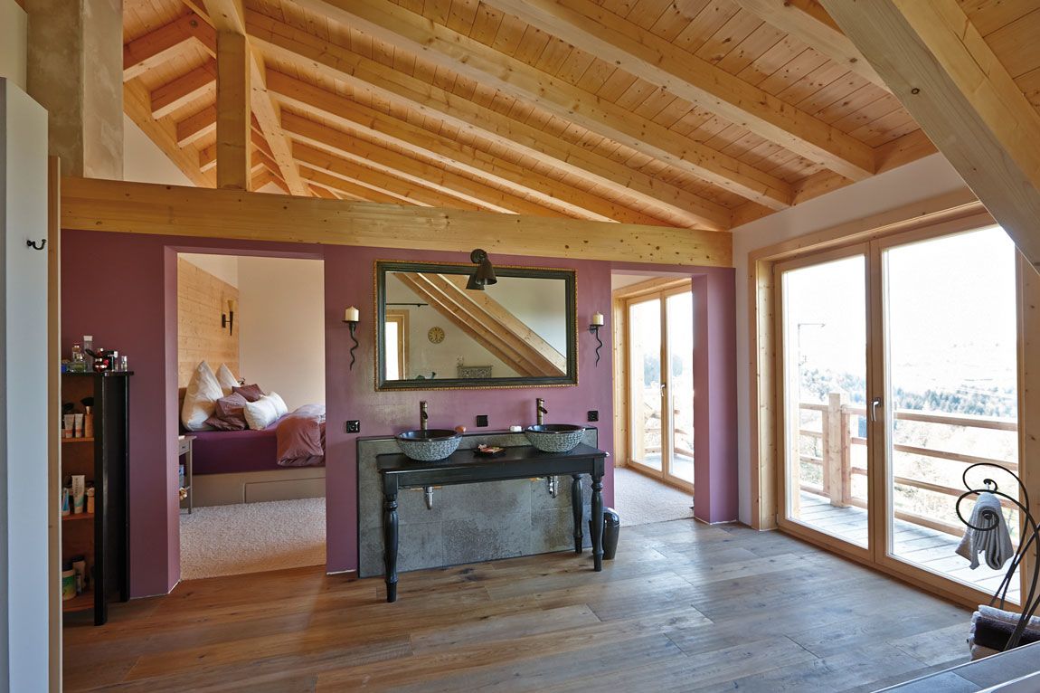 Bad und Schlafzimmer in einem massiv gebauten Holzhaus